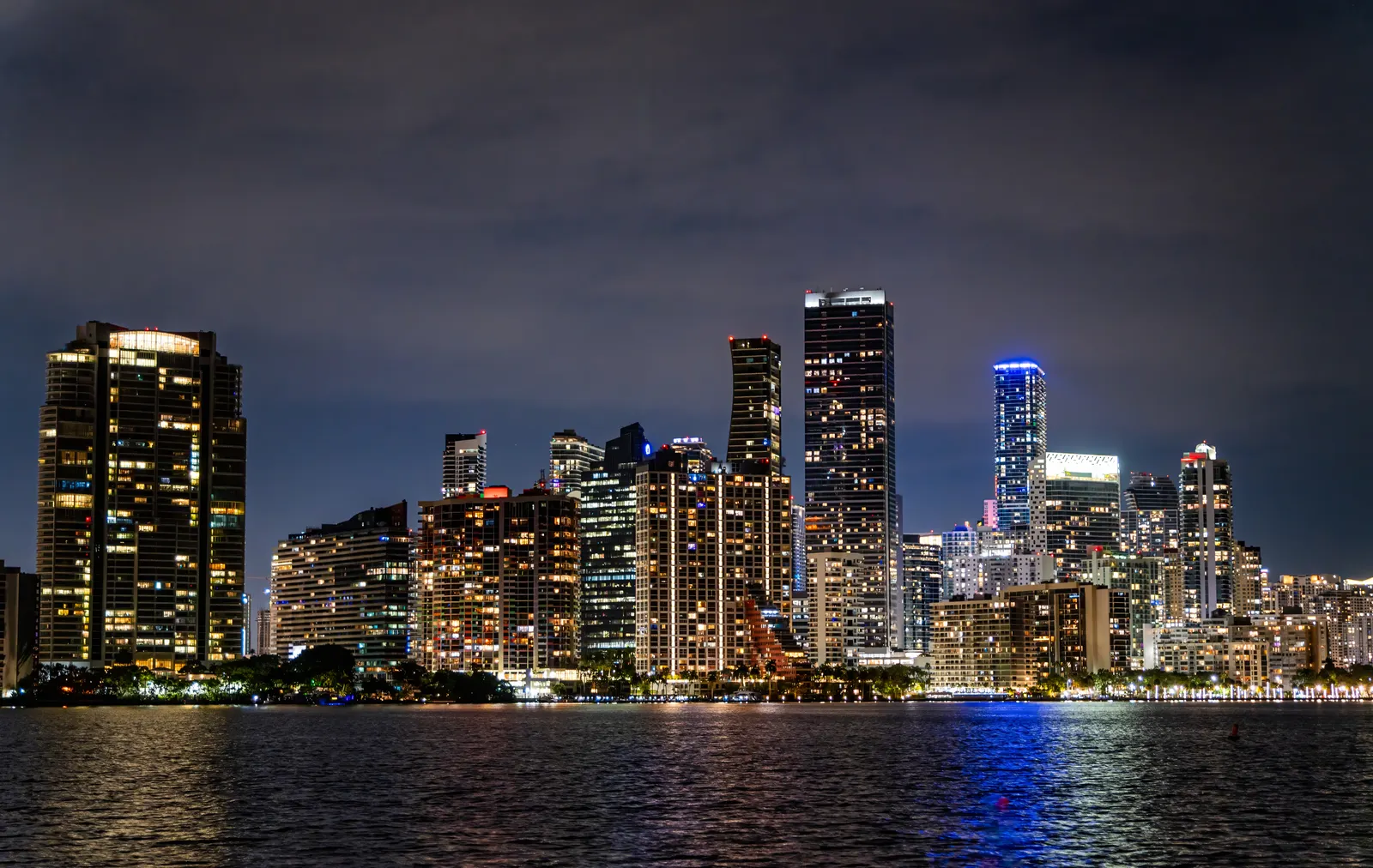 Illuminated Miami skyline at night over the water