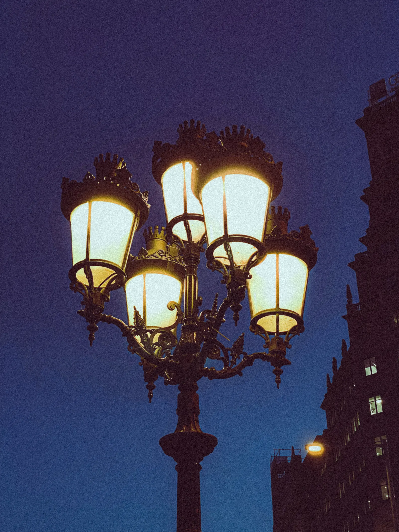 A vintage street lamp glowing at night in Barcelona