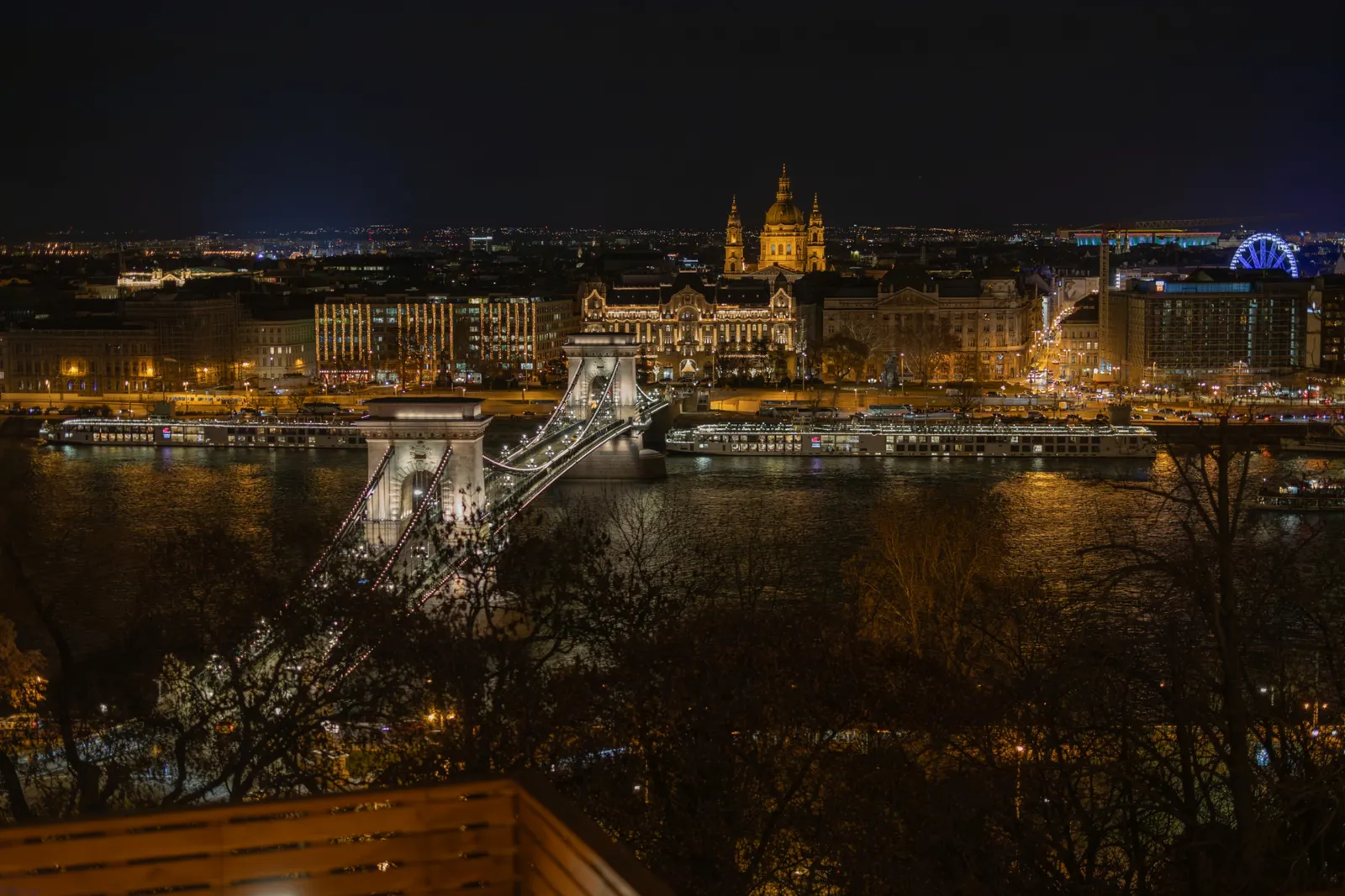 Budapest lights and historic architecture glowing above the river at night