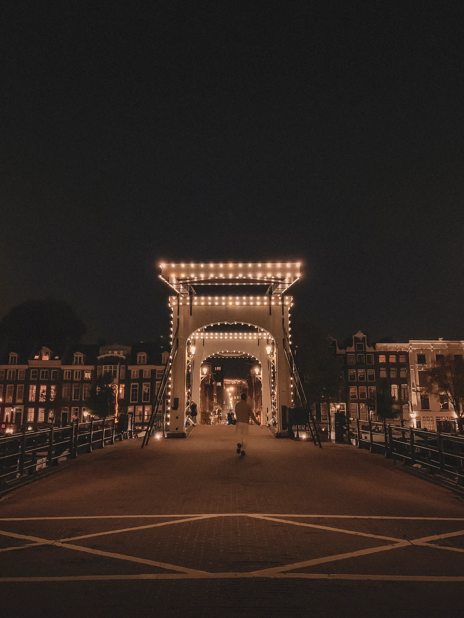 A lit bridge and canal scene in Amsterdam after dark