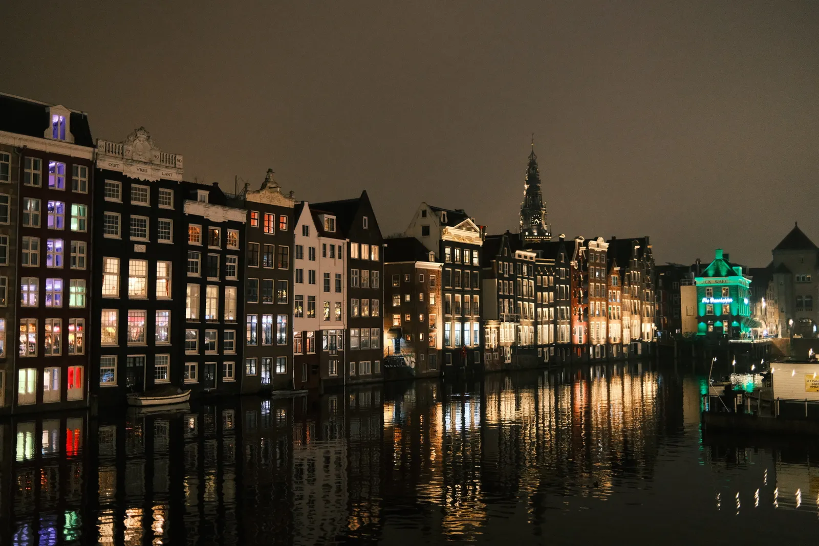 Amsterdam canal houses reflected in dark water at night